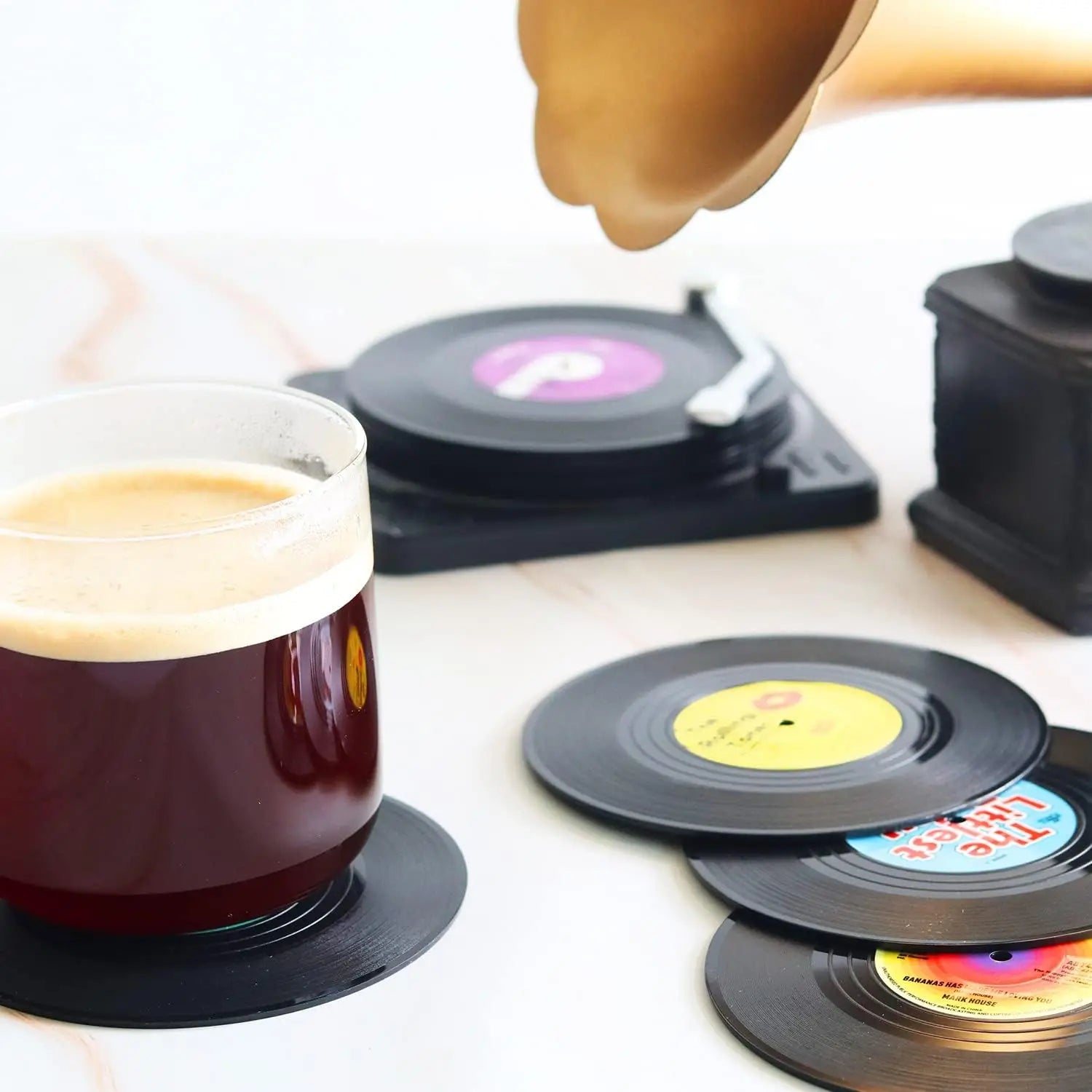 Vinyl record coasters with a cup of coffee on a white surface